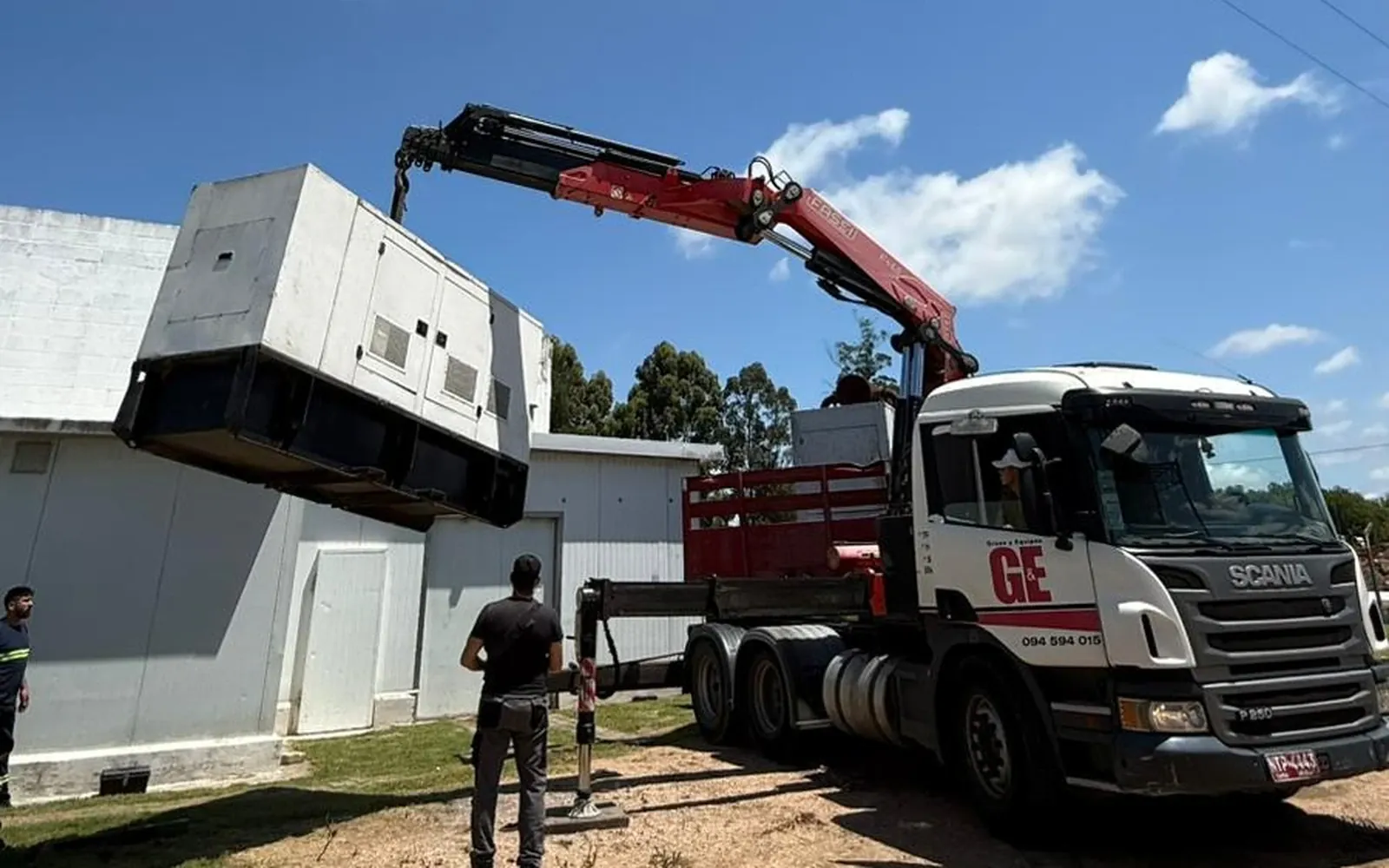 Grúa trasladando un grupo electrógeno en una planta industrial